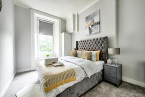 Two Bed Stylish Apartment in Heart of West End في غلاسكو: غرفة نوم بسرير كبير ونافذة