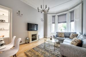 ein Wohnzimmer mit einem Sofa und einem Tisch in der Unterkunft Two Bed Stylish Apartment in Heart of West End in Glasgow