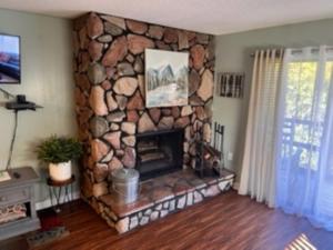 a living room with a stone fire place at Bearadise Retreat At English Mountain Condo in Sevierville
