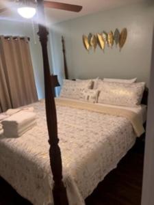 a bedroom with a bed with white sheets and a fan at Bearadise Retreat At English Mountain Condo in Sevierville