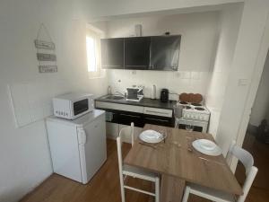 una pequeña cocina con mesa y microondas en Mondschein Appartement+Netflix+zentral, en Bochum