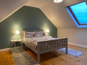 een slaapkamer met een bed, 2 lampen en een raam bij Joe's Place, Central Location West Cork near Clonakilty in Ballingurteen