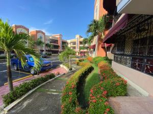 uma rua com flores ao lado de um edifício em Dominican Rep Nice Apt-2Inverter and Transformer for the power if goes off- 2Good transportation-Comercial area em La Estrella