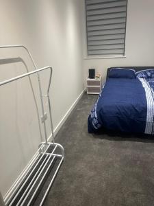 a bedroom with a bed with a blue comforter at Flat beckenham road in Beckenham