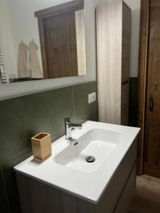 a bathroom with a white sink and a mirror at Ski House Courmayeur in Courmayeur