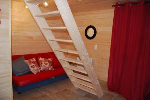 una scala in una camera con divano rosso di Chalet le Petit Coeur a Xonrupt-Longemer
