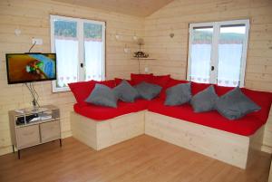 un divano rosso in una stanza con TV di Chalet le Petit Coeur a Xonrupt-Longemer