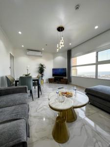 ein Wohnzimmer mit Sofa und Tisch in der Unterkunft The Red Sea Apartment شقة البحر الأحمر in Dschidda