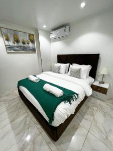a bedroom with a large bed with two towels on it at Fantom Red Sea شقة البحر الأحمر in Jeddah