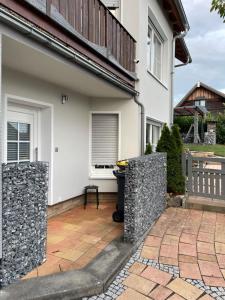 une maison avec une terrasse et une poubelle dans l'établissement Apartment/Ferienwohnung im ruhigen Calden in der nähe von Kassel, à Calden