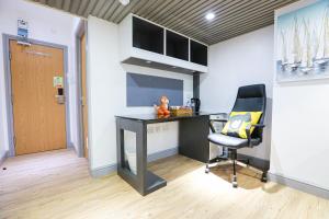 ein Büro mit einem Schreibtisch und einem Stuhl in einem Zimmer in der Unterkunft B103 Urban Oasis loft in Coventry