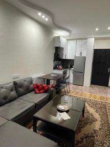 a living room with a couch and a table and a kitchen at Apartment - "exclusive" in Tbilisi City