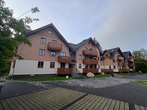 an apartment building with balconies and a parking lot at Szum Łomnicy in Karpacz