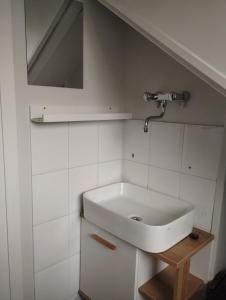 a white bathroom with a sink and a mirror at Charming Family Home in Delft