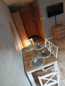 een houten tafel met borden in een kamer bij Szum Łomnicy in Karpacz