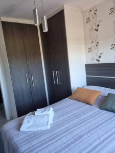 a bedroom with a bed with blue sheets and brown cabinets at Conforto Tranquilidade apto c garagem in Curitiba