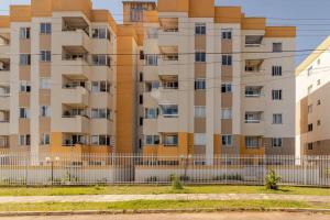 an apartment building with a fence in front of it at Apto completo 2 quarto 2 banheiro universidade Positivo Volvo C garagem in Curitiba