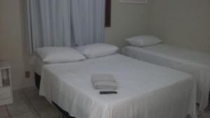a bedroom with two beds with white sheets at Pousada Hostel Villa Bella Mar in Natal