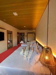 - une chambre avec un lit doté d'oreillers et d'une lampe dans l'établissement Villa Jucá Casa 03, à Porto de Pedras