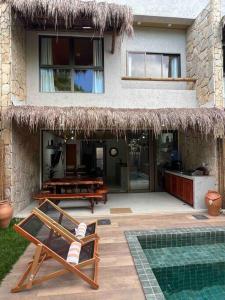 a house with a pool and a chair and a house at Villa Jucá Casa 03 in Pôrto de Pedras