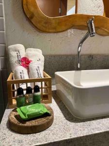 La salle de bains est pourvue d'un lavabo et de serviettes sur un comptoir. dans l'établissement Villa Jucá Casa 03, à Porto de Pedras
