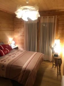Chalet Cervus في فون-رومو-أوديللو-فيا: غرفة نوم بسرير كبير ومصباح