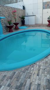 a large swimming pool with blue water in a yard at Casa em Condomínio, Piscina Privativa e Área Gourmet in Camaçari