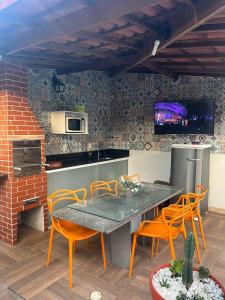 Casa em Condomínio, Piscina Privativa e Área Gourmet في كامساري: مطبخ مع طاولة وكراسي في مطبخ