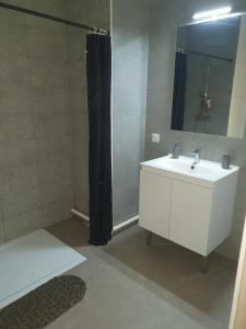 La salle de bains est pourvue d'un lavabo blanc et d'une douche. dans l'établissement SPA Détente jacuzzi cinéma farniente, à Dugny