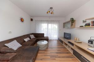 a living room with a brown couch and a tv at Vila Lavanda in Bribir