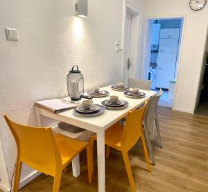 mesa de comedor con sillas y mesa blanca con platos en Messeapartment an der Altstadtmauer, en Núremberg