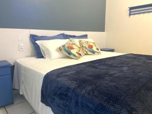 una camera con un letto con due cuscini sopra di Pousada Poente do Sol a Garopaba