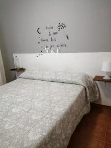 Un dormitorio con una cama y una pared con palabras. en Reposo tranquilo en entorno rural, en Cetina