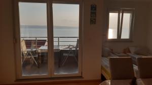 a room with a balcony with a view of the ocean at Inga's Apartment in Starigrad-Paklenica