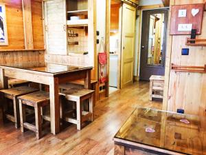 a room with a wooden table and a glass table at STANDING 5 Pax LES MENUIRES in Les Menuires