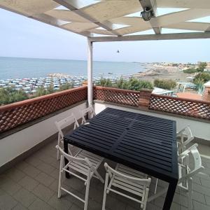 a black table and chairs on a balcony with the ocean at B&B Antico Porto Tarquinia in Tarquinia