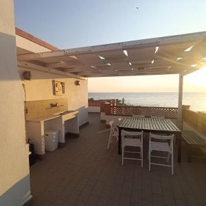 a patio with a table and chairs and the ocean at B&B Antico Porto Tarquinia in Tarquinia