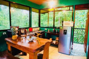 a kitchen with a wooden table and a refrigerator at Casita Verde, 800 mts from beach in Playa Hermosa +60 photos
