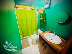 a green bathroom with a sink and a toilet at Casita Verde, 800 mts from beach in Playa Hermosa
