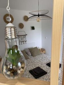 Escapade Normande avec son sauna privé في Le Tourneur: غرفة نوم مع سرير و مزهرية على طاولة
