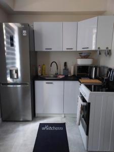 a kitchen with white cabinets and a stainless steel refrigerator at Apartament Centrum 2 in Wałbrzych