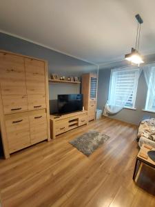 a living room with a tv and a dresser at Apartament Centrum 2 in Wałbrzych