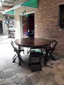 a wooden table and chairs on a patio at Casa de Temporada no Paraíso Guaraú in Peruíbe