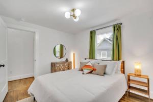 Un dormitorio blanco con una cama grande y una ventana. en Haynesworth Manor, en Greenville