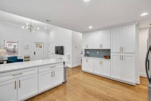 cocina con armarios blancos y comedor en Haynesworth Manor, en Greenville