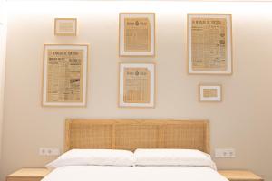 1 dormitorio con 1 cama con 4 cuadros en la pared en Casa Tai, en Tivenys