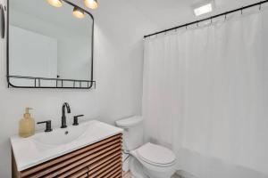 Un baño con lavabo, inodoro y espejo. en Haynesworth Manor, en Greenville 11 fotos más