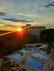 a view of two swimming pools at sunset at Hotel Park Veredas - Rio Quente Flat 225 in Rio Quente