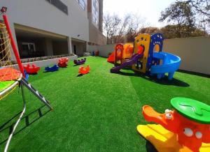 un parque infantil con equipo de juegos en la hierba en Hotel Park Veredas - Rio Quente Flat 225, en Rio Quente