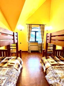 2 camas en una habitación amarilla con ventana en Hotel Villa Alexander Dilijan, en Dilijan